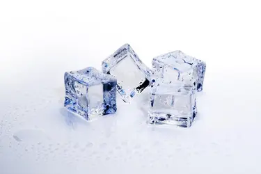 Vier Eiswürfel liegen nebeneinander und schmilzen