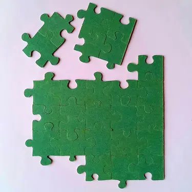 grüne Puzzleteile auf einem weißen Untergrund