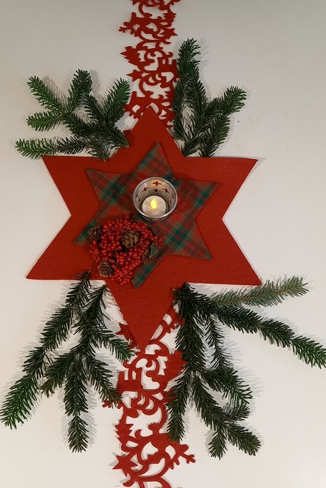 Weihnachtsschmuck bestehend aus Tannezweigen, Filzschmuck und Kerze