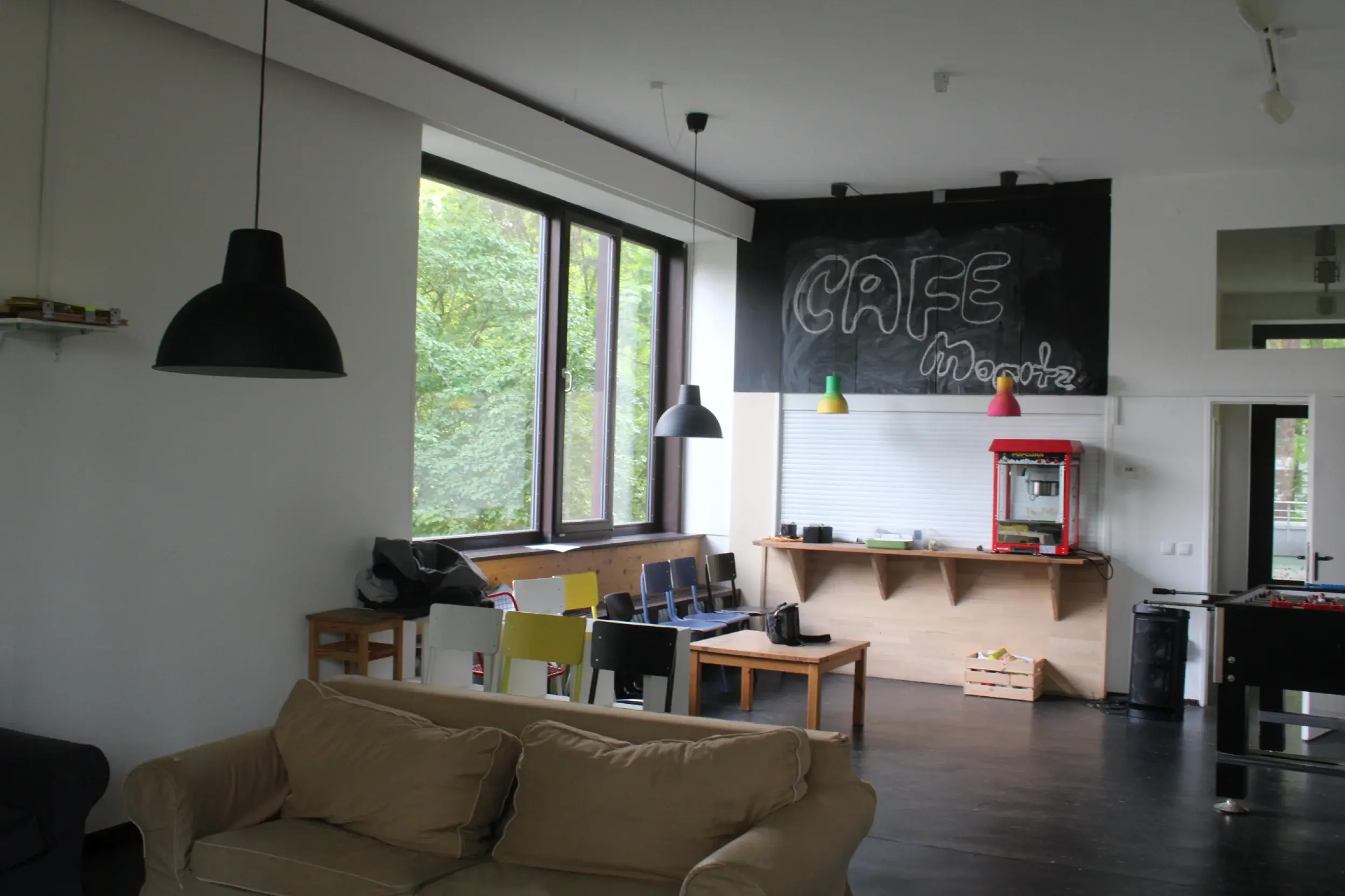 Blick in den Raum Richung Bar mit Stühlen, Tischen und Sofas