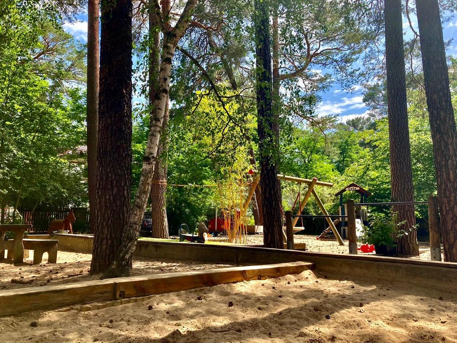 Das Gelände des Kindergartens mit Schaukeln und Sandkasten