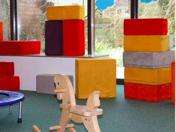 Schaukelpferd und bunte Bausteine stehen in einem Raum im Kindergarten